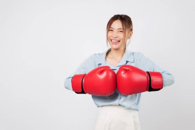 Asyalı genç bir kadın tarafından yetiştirilmiş boks eldivenleri. İş gururuyla dövüşmeye hazır. Güçlü bir gülümseme ve koruma duruşu kırmızı boks eldiveni ve formda yaşam tarzını ifade eder. izole stüdyo beyaz arkaplan
