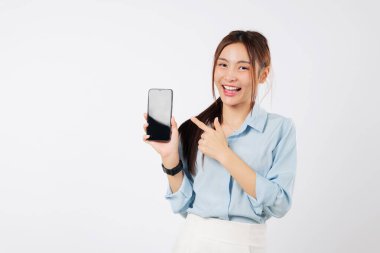 Elinde cep telefonu olan gülümseyen Asyalı kadın boş ekranını işaret ediyor. O mutlu ve heyecanlı, yeni telefonunu gösteriyor. izole stüdyo beyaz arkaplan