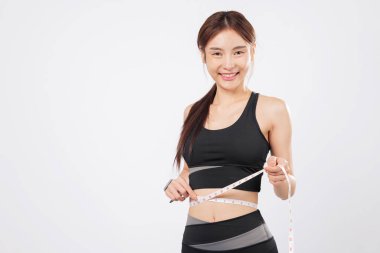 İlerleyişini ölçün ve belini nazik bir gülümsemeyle ölçün, bu zinde ve mutlu kadın gururla kilo verme yolculuğunu spor ve sağlıklı bir yaşam tarzında sergiliyor. izole stüdyo beyaz arkaplan