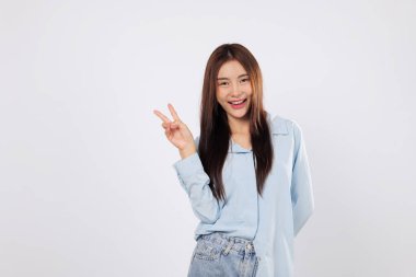 V işaretinde parlayan parmaklarıyla zafer ifadesi, neşeli Asyalı kadın kişisel zafer anını kutluyor, heyecanını ve kendine güvenini gösteriyor. izole edilmiş beyaz arkaplan