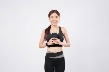 Telefonu elinde ve başka bir telefon anının yakalanmasıyla bu atlet aktif yaşam tarzını ve egzersiz motivasyonunu desteklemek için mobil teknolojiyi kucaklıyor. izole stüdyo beyaz arkaplan