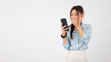 Kadın şok edici Asyalı. Şaşırtıcı bir ağzı var. Duygu yüklü, cep telefonu okuyan endişeli genç bir kadın telefonunda şok olmuş bir ifadeyle kötü haber görür.