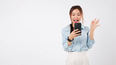 Mutlu genç Asyalı kadın, cep telefonu ve kredi kartı kullanarak heyecan verici duygular. Alışveriş, kart kazananı sosyal bir bayanı şaşırtır. Çevrimiçi alım onaylandı, stüdyo beyaz arka plan