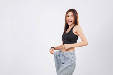 İnce beline büyük beden pantolon giymiş. Zindelik zaferinin kanıtı. Başka bir büyük çiftle, büyüklüklerini ve gülümsemelerini neşeyle karşılaştırıyor. izole stüdyo beyaz arkaplan