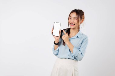 Cep telefonu ekranını işaret eden mutlu bir Asyalı kadın boş ekranını gösteriyor. O, bu modern telefonu tutmak için heyecanlı. izole stüdyo beyaz arkaplan