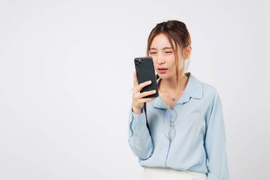 Miyop görme problemi. Miyop, telefon ekranına yakından bakan genç Asyalı kadını, göz yorgunluğunu ve mobil kullanım nedeniyle görme kaybını etkiler. izole stüdyo beyaz arka plan, Zayıf Görme Konsepti