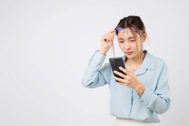 Telefon kullanırken görme sorunu, ekrana bakan kadın, gözlük, görme bozukluğu ve yaştan sonra erken görme kaybı. Göz hastalıkları stüdyo beyaz arka plan