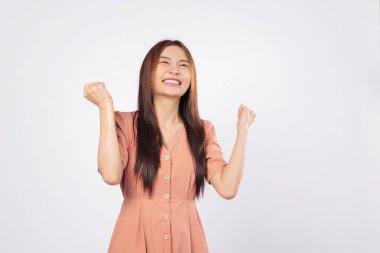 Gözlerindeki başarı ve poziyondaki başarı kadın heyecanla gülümsüyor ve yumruklarını kaldırıyor özgüvenini dışa vuruyor stüdyo beyaz arka plan iş profili tarzı