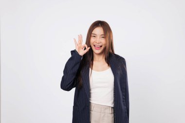 Tamam sinyal okey Asyalı bir kadın olarak mutlu bir şekilde parmak işareti göstererek onay ve olumlu tutumu izole edilmiş beyaz stüdyo arka planında en az seviyede gösterir