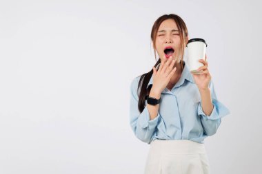 Uyku, uyumaktan yorgun düşmüş bir kadının ağzı açık esnemesi, elinde hazır kahve fincanı tutması, uykusuzluk ve yorgunluk göstergesi, dinlenme ve stres eksikliği.