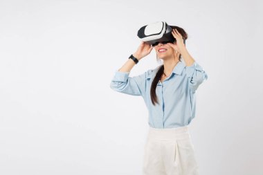 Sanal gerçeklik oyunu için VR kulaklığı kullanan genç Asyalı kadın, gençlerin geleceği hakkında heyecanlı, çevrimiçi teknoloji deneyimliyor, VR dünyalarını ve maceralarını zevkli, izole beyaz arka planda keşfediyor.