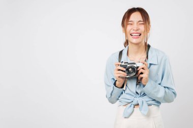 Elinde kamerayla gezen turist kadın, gururlu turist kendini mutlu hissediyor. Heyecanlı Asyalı genç bayan gezgin parlak enerjisiyle tatilin tadını çıkarıyor. izole stüdyo beyaz arkaplan
