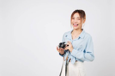 Turist kadın elinde kamerayla gülümsüyor, tatildeki neşeli bir turist. Mutlu Asyalı gezgin yaz tatilinin tadını çıkarıyor, yeni maceralara hazır. izole stüdyo beyaz arkaplan