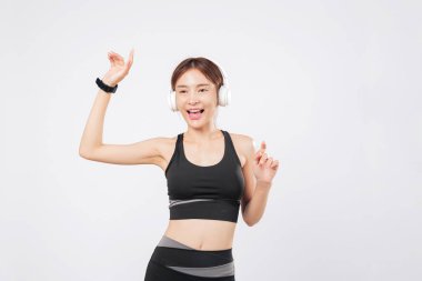 Kulaklıklarla eğitildiği sırada dans onun ruhundadır. Vücudu yaşadığını hissediyor ve bir kez daha dans etmeye başlarken gülümsüyor. izole stüdyo beyaz arkaplan