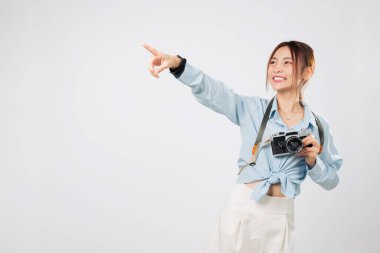 Kameralı turist boş alanı gösteriyor. Gururlu turist anı. Portre Mutlu Asyalı genç bayan gezgin heyecanlı yaz tatili boyunca fotoğrafçılıktan zevk alıyor. izole stüdyo beyaz arkaplan