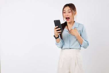 Cep telefonunu tutan bir kadın şaşkınlıkla bakar, gerçek bir şok gösterir. Haberler, akıllı telefonundan ani bir şok etkisi yaratıyor. izole stüdyo beyaz arkaplan