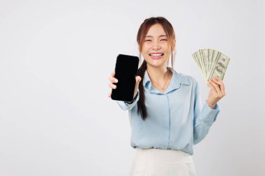 Telefon ekranı ve mutlu gülüşlü para gösteren Asyalı Kadın, heyecanlı mobil uygulama parası dijital alışveriş başarısı ve çevrimiçi finans sektöründeki kişisel büyümeyi ön plana çıkarıyor. izole stüdyo beyaz arkaplan