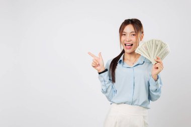 Elinde para tutan ve boş bir yeri işaret eden gülümseyen kadın, dolar parası açıkça görülüyor ki mali şansı ve yatırımın geri dönüşü mutlulukla kutlanıyor. izole stüdyo beyaz arkaplan