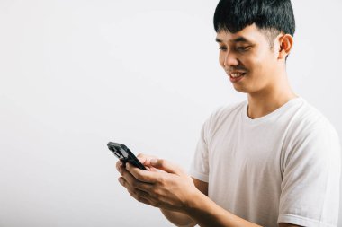 Sosyal medya stüdyosu için cep telefonu kullanan Asyalı gülümseyen genç adam, izole edilmiş beyaz arka plan, akıllı telefondan mesaj yazan mutlu yaşam tarzı erkekler, online mobil uygulama