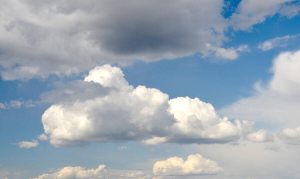 White fluffy clouds and dark rains clouds in the deep blue sky, cloud background, natural sky photo