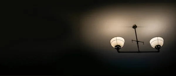 暗い部屋の背景に壁に古い古代のランプ 暗い光 — ストック写真