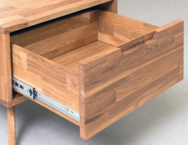 Opened drawer close view photo, wooden furniture elements background. Furniture details