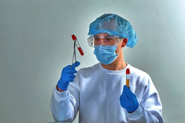 Koronavirüs COVID19, HIV, ebola ya da diğer tehlikeli enfeksiyonlar için kan testi yapan maskeli bir doktor. Tıbbi geçmiş, şablon, duvar kağıdı. Coronavirus hastalığı konsepti