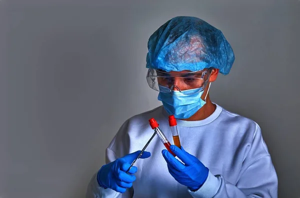Doctor in mask performing blood test for coronavirus COVID19, HIV, ebola or other dangerous infection, illness. Doctor portrait, medical background, template, wallpaper. Coronavirus disease