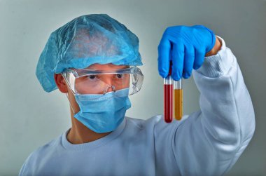 Koronavirüs COVID19, HIV, ebola ya da diğer tehlikeli enfeksiyonlar için kan testi yapan maskeli bir doktor. Tıbbi geçmiş, enstrümanlar, şablon, duvar kağıdı. Coronavirus hastalığı konsepti