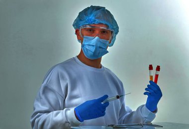 Koronavirüs COVID19, HIV, ebola ya da diğer tehlikeli enfeksiyonlar için kan testi yapan maskeli bir doktor. Tıbbi geçmiş, enstrümanlar, şablon, duvar kağıdı. Coronavirus hastalığı konsepti