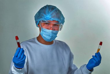 Maskeli doktor gülümseyerek Coronavirus COVID19, HIV, ebola veya diğer tehlikeli enfeksiyonlar için kan testi tüpünü tutuyor. Tıbbi geçmiş, enstrümanlar, şablon, duvar kağıdı. Coronavirus hastalığı konsepti