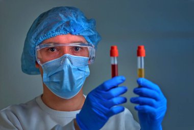 Kan testi tüpü, koronavirüs COVID19, HIV, ebola veya diğer tehlikeli enfeksiyonları tutan maskeli bir doktor. Tıbbi geçmiş, enstrümanlar, şablon, duvar kağıdı. Coronavirus hastalığı konsepti. Doktor portresi