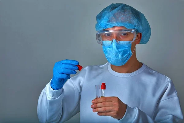 Doctor in mask performing blood test for coronavirus COVID19, HIV, ebola or other dangerous infection. Medical background, template, wallpaper. Coronavirus disease concept