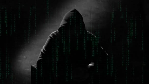 フードのインタビュービデオ映像の匿名の男 椅子に座って話している謎の男 見える顔映像のない匿名のハッカーインタビュー コンピュータハッカーの概念的な背景 — ストック動画