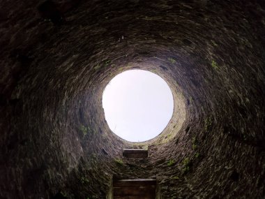 Taş kuyu çukuru, eski kuyu inşaatı içeriden, kavramsal arka plana düşer.