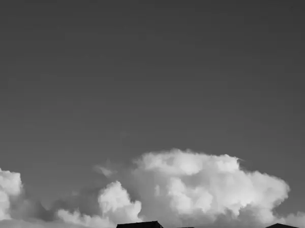 stock image Summer white fluffy cumulus clouds in the deep blue sky. Black and white monochrome grayscale photo