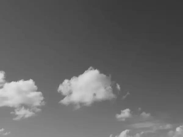 stock image Summer white fluffy cumulus clouds in the deep blue sky. Black and white monochrome grayscale photo