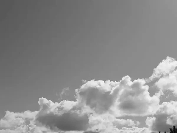 stock image Summer white fluffy cumulus clouds in the deep blue sky. Black and white monochrome grayscale photo