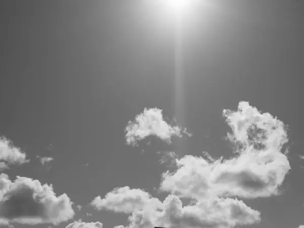 stock image Summer white fluffy cumulus clouds in the deep blue sky. Black and white monochrome grayscale photo