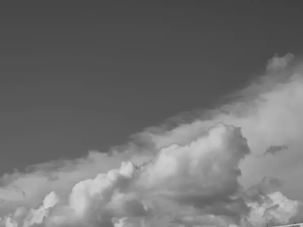 stock image Summer white fluffy cumulus clouds in the deep blue sky. Black and white monochrome grayscale photo