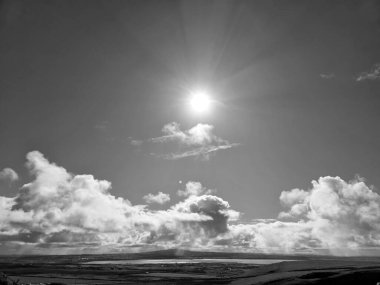 White fluffy clouds in the summer sky and natural landscape black and white background clipart