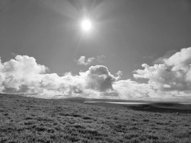 White fluffy clouds in the summer sky and natural landscape black and white background clipart