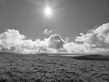 White fluffy clouds in the summer sky and natural landscape black and white background clipart