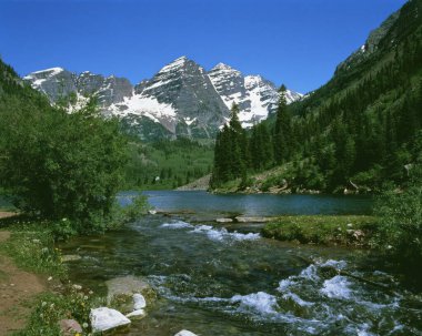 Karaçam Ağaçları, Akıntılar ve Gökyüzü Altındaki Görkemli Dağlarla Serene Highland Manzarası