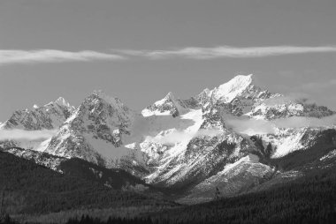 Majestic Snow-Capped Mountain Under a Cloudy Sky with Lush Greenery and Glacial Features clipart