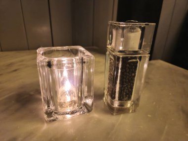 Candle and pepper on a restaurant table background clipart