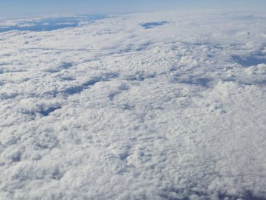 Airplane flying over white clouds background clipart