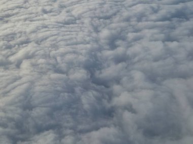 Airplane flying over white clouds background clipart