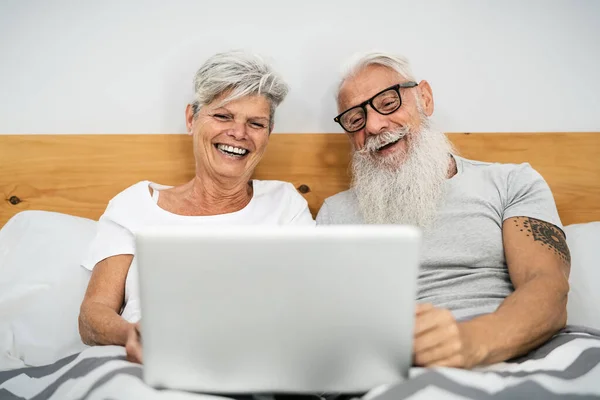 Šťastný Starší Pár Baví Používání Notebooku Zatímco Posteli Pod Přikrývkami — Stock fotografie