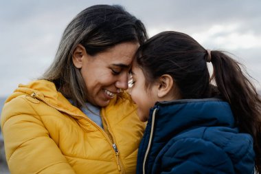 Happy Latin mother with her daughter having tender moment outdoor - Family and love concept